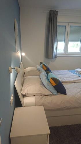 a bedroom with a bed with a pillow on it at Apartments Nina in Rab