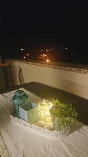 a tray with a candle and a plant on a balcony at Apartments Nina in Rab