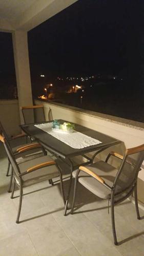 a black table and chairs on a balcony at night at Apartments Nina in Rab