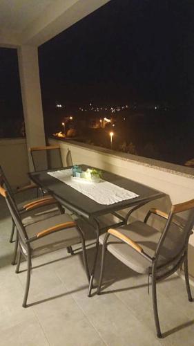 a table and chairs on a balcony at night at Apartments Nina in Rab