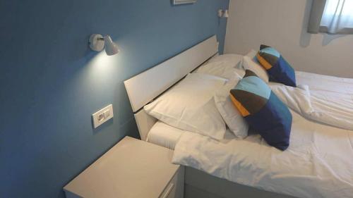 a small bedroom with a bed with white sheets and pillows at Apartments Nina in Rab