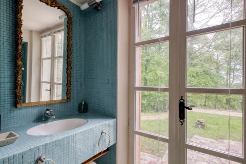 une salle de bain avec un lavabo, un miroir et une fenêtre dans l'établissement Le Domaine de L'Etoile, à Paley