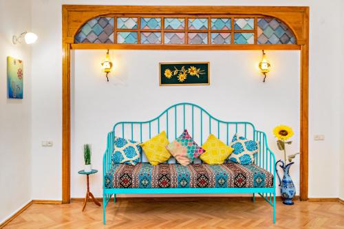een blauw bed met kleurrijke kussens in een kamer bij ★ Blue Door Rhapsody ★ - Special Stay In Old Town! in Tbilisi City