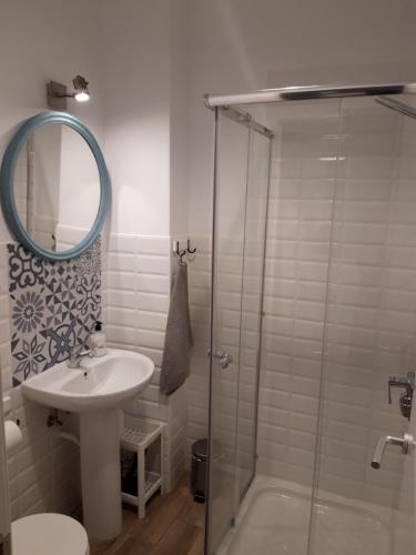a bathroom with a sink and a glass shower at Acogedor Apartamento Centro Benalmadena in Benalmádena