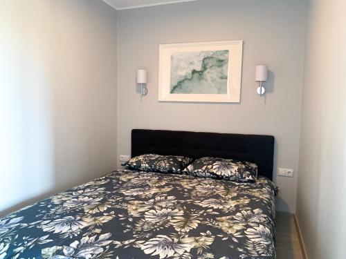 um quarto com uma cama e uma fotografia na parede em Patogus Miegas IV em Anykščiai