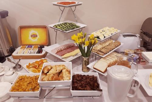 a table with many different types of food on it at Central Hotel Radviliškis in Radviliškis