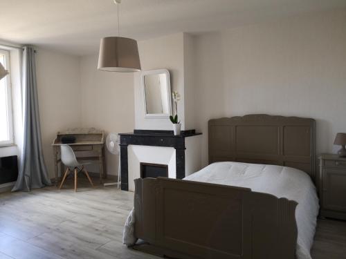 a bedroom with a bed and a desk and a fireplace at Appartement du GET in Revel