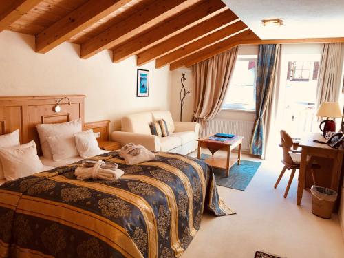 una camera da letto con un letto con un cane steso sopra di Hotel Berghof a Nauders