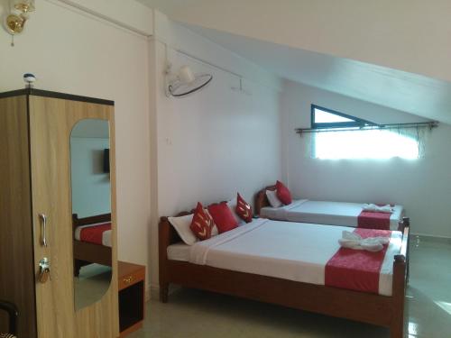 a small bedroom with a bed and a mirror at Sulawado Resort in Cherrapunji