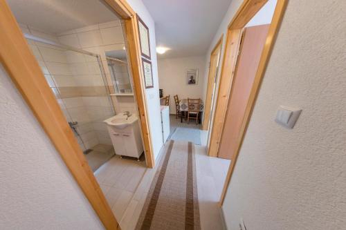 einen Flur, der zu einem Bad mit einem Waschbecken führt in der Unterkunft Apartment Resaa in Bihać