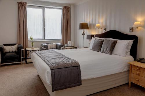 a bedroom with a large bed with a large window at Best Western Princes Marine Hotel in Brighton & Hove