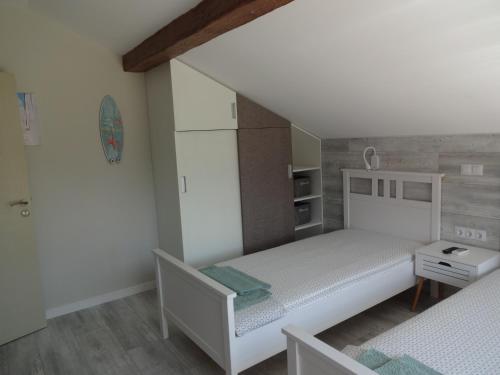 a small bedroom with a white bed and a staircase at Apartments Dona in Chernomorets