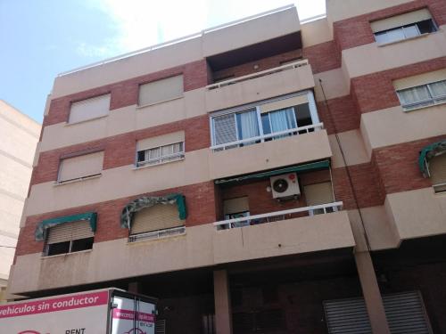 um edifício com janelas e um camião estacionado em frente em Villa Carmen em San Juan de Alicante