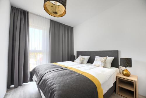 Un dormitorio con una cama y una ventana grande. en Coffee Inn, en Gdansk