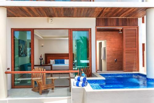 a villa with a swimming pool and a bedroom at Aquastar Unique Hotel & Apartments Mahahual in Mahahual