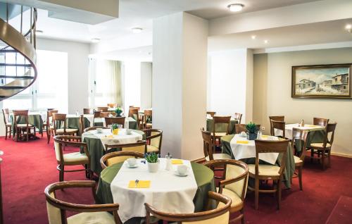 a dining room with white tables and chairs at Athens Odeon Hotel in Athens