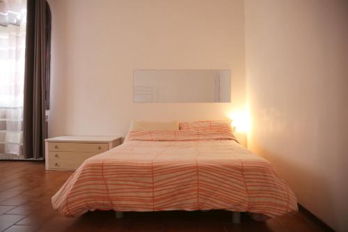 a bedroom with a bed with a striped blanket at Casa Martini in Venice