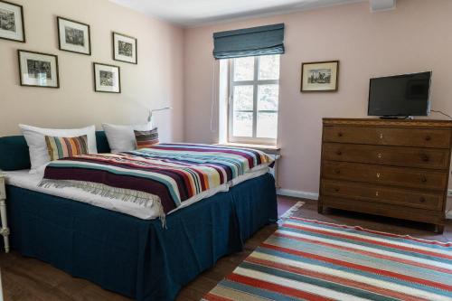 a bedroom with a bed with a television and a dresser at meinsachsenwald forsthaus friedrichsruh in Aumühle