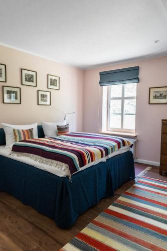 a bedroom with a bed with a colorful blanket on it at meinsachsenwald forsthaus friedrichsruh in Aumühle