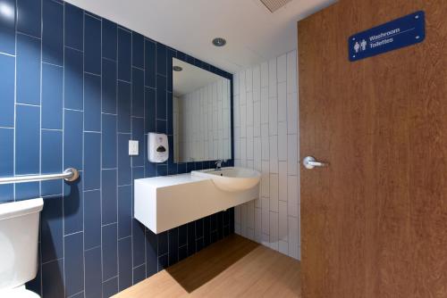 オタワにあるDoubleTree by Hilton Ottawa Downtownの青いタイルのバスルーム(洗面台、トイレ付)