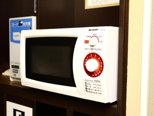 a white microwave oven sitting on a shelf at APA Hotel Ningyocho Ekikita in Tokyo
