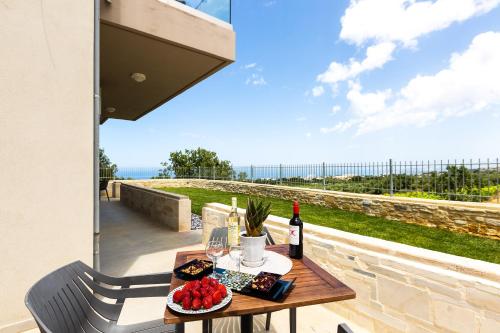 a table with a bottle of wine and fruit on a patio at Vigla Suites in Rethymno Town