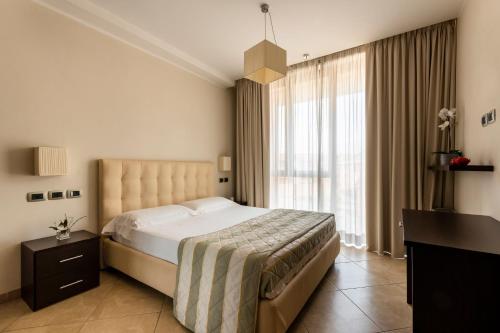 a bedroom with a large bed and a large window at ApartHotel Anghel in Siena