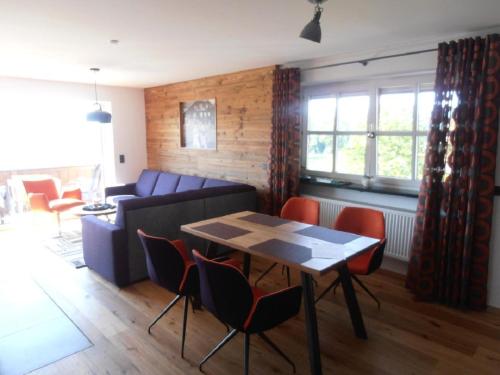 a living room with a couch and a table and chairs at Wellness Ferienwohnungen Zellertalblick in Drachselsried