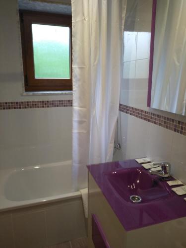 a bathroom with a purple sink and a bath tub at Casa de Aldea La Xunta in Cangas de Onís
