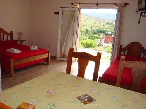 Cabañas El Refugio de Juan في مينا كلافيرو: غرفة مع طاولة وكراسي ونافذة