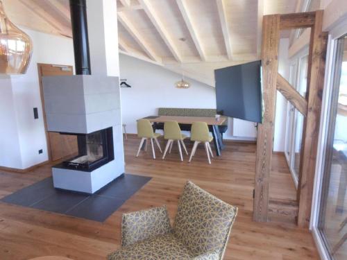 a living room with a dining table and a fireplace at Wellness Ferienwohnungen Zellertalblick in Drachselsried