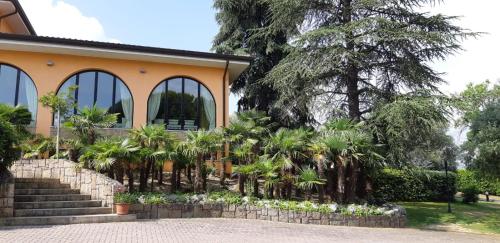 a house with a bunch of palm trees in front of it at Villa Del Poeta in Arqua Petrarca