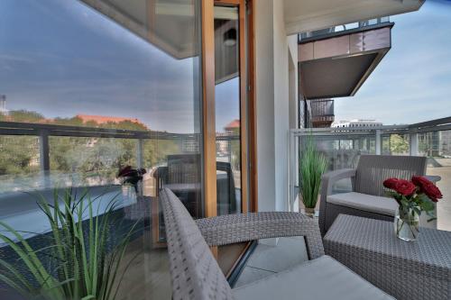 a balcony with a table and chairs and a view at ApArt Bulwary Wrocław in Wrocław