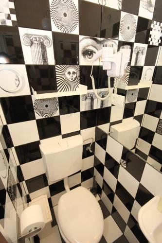 a bathroom with a black and white checkered wall at The Hostel in Zadar