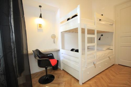 a room with a white bunk bed and a chair at The Hostel in Zadar