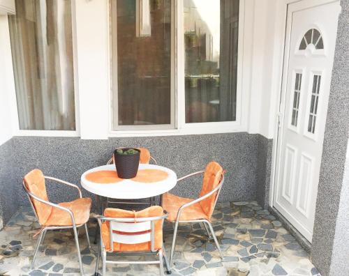 uma mesa e cadeiras num alpendre com uma janela em Apartman Marina em Mostar