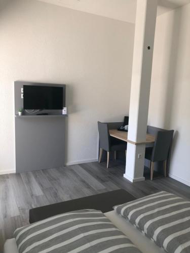 a room with a bed and a table with a television at Hotel Lumi in Freiburg im Breisgau