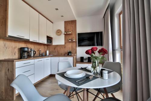 a kitchen with a table with a vase of flowers on it at ApArt Bulwary Wrocław in Wrocław