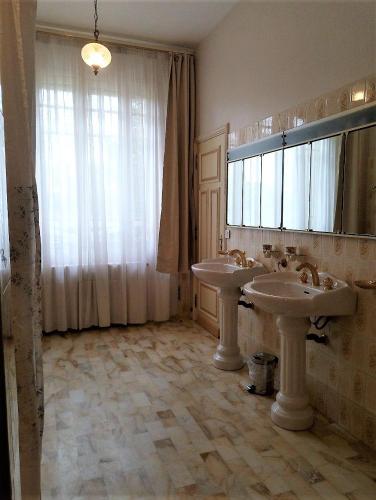 a bathroom with two sinks and a large window at Maison Lalongère in Longueville
