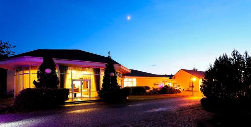 a house is lit up at night with purple lights at Hotel Preemier in Marcinowice