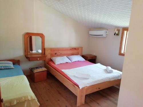 1 dormitorio con 2 camas y espejo en Medusa Camping, en Patara