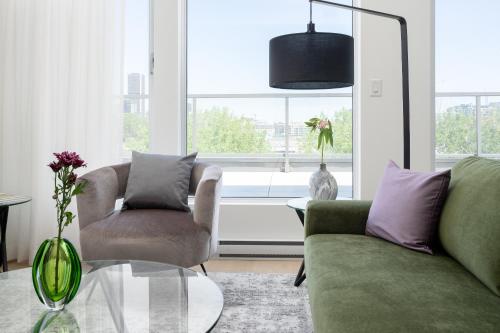 a living room with a couch and two chairs and a table at Le Se7t Penthouses in Montréal