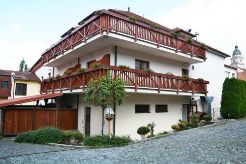 a white building with a balcony on top of it at Kounický dvůr in Dolní Kounice