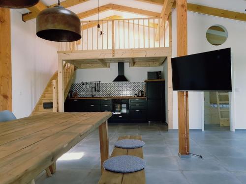 eine große Küche mit einem Holztisch und einem TV in der Unterkunft Heimatliebe Ferienwohnung in Börgerende-Rethwisch