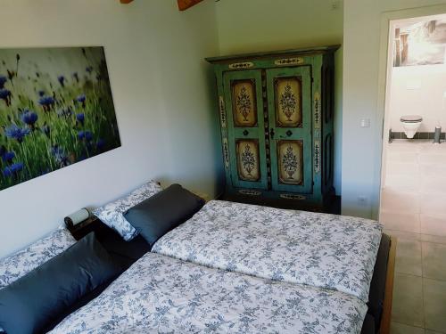 a bedroom with a bed and a green cabinet at Heimatliebe Ferienwohnung in Börgerende-Rethwisch