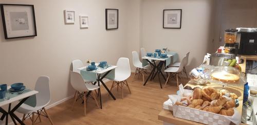 una habitación con mesas y sillas y una mesa con pan en EVA LUXURY ROOMS CAGLIARI, en Cagliari