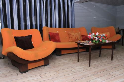two orange chairs and a coffee table in a room at NaBaDa in Tsʼageri