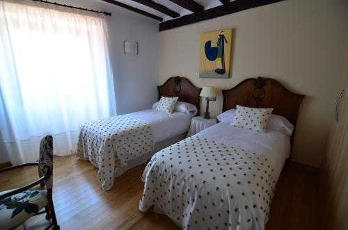 a room with two beds and a window with at Casa de la Cadena in Asiáin