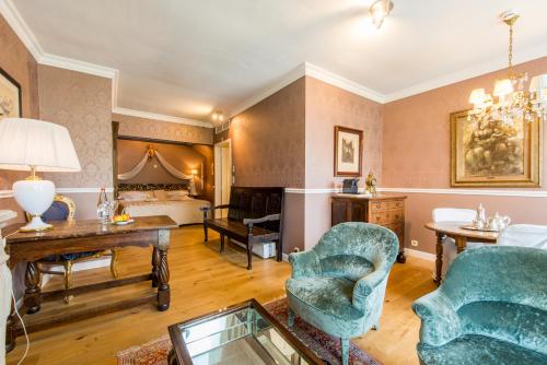 a living room with two chairs and a bed at Boutique Hotel Die Swaene in Bruges