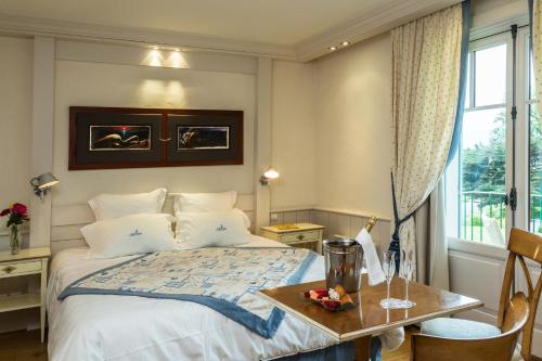 a bedroom with a bed and a table and a window at Villa Cécile in Yvoire